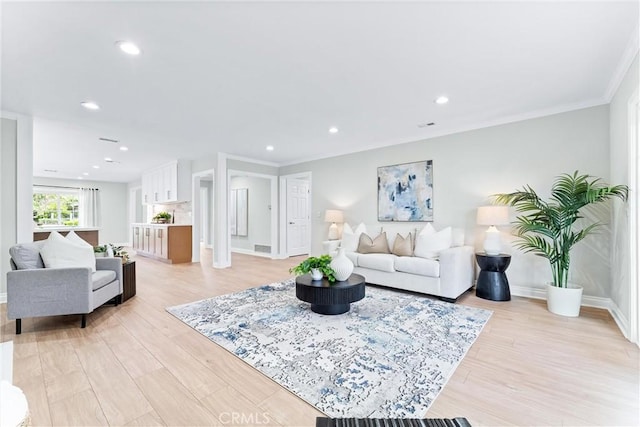 living area with baseboards, light wood-style flooring, recessed lighting, and ornamental molding