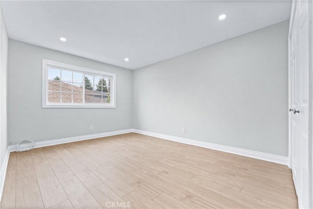 empty room with baseboards, light wood finished floors, and recessed lighting