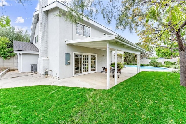back of house featuring a patio area, stucco siding, a chimney, and central air condition unit