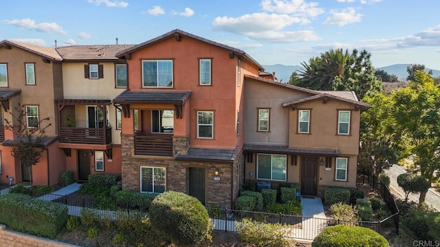 view of property with stone siding, stucco siding, and a mountain view