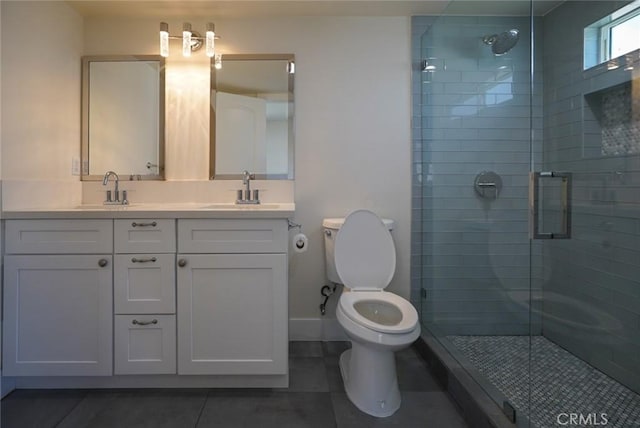 bathroom with tile patterned floors, a stall shower, toilet, double vanity, and baseboards