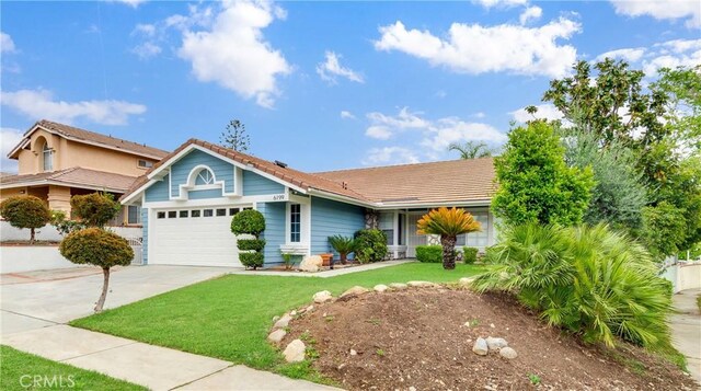 view of front facade featuring an attached garage, driveway, a front lawn, and a tiled roof