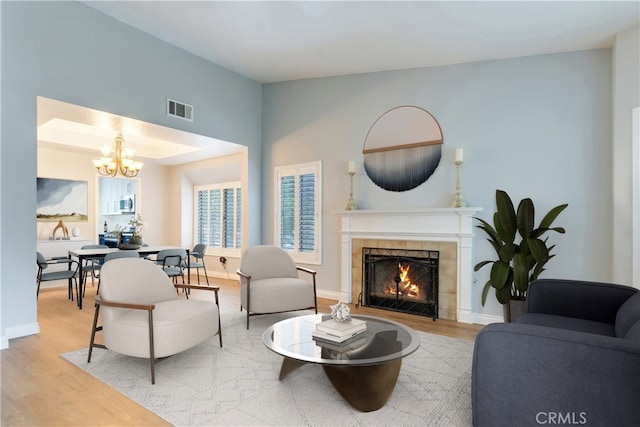 6199 Cabernet Pl, Rancho Cucamonga, CA 91737 - living area with wood finished floors, a chandelier, a tiled fireplace, and baseboards