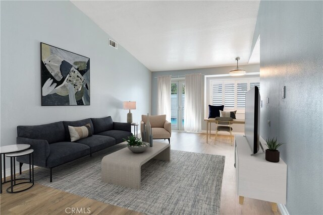 living room featuring wood finished floors, vaulted ceiling, and baseboards