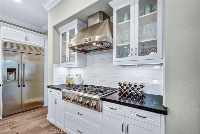 135 Bridle Path, Irvine, CA 92602 - kitchen featuring appliances with stainless steel finishes, wall chimney exhaust hood, ornamental molding, dark countertops, and tasteful backsplash