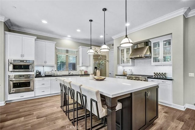 135 Bridle Path, Irvine, CA 92602 - kitchen featuring wall chimney range hood, appliances with stainless steel finishes, white cabinetry, a sink, and decorative backsplash