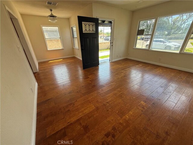 spare room featuring dark wood-style flooring and baseboards
