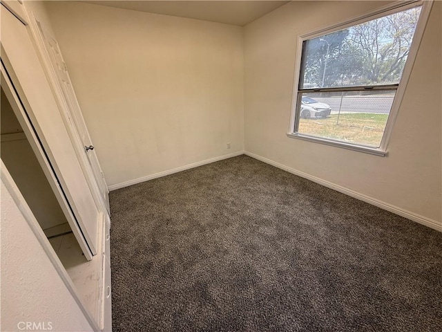 unfurnished room featuring carpet and baseboards