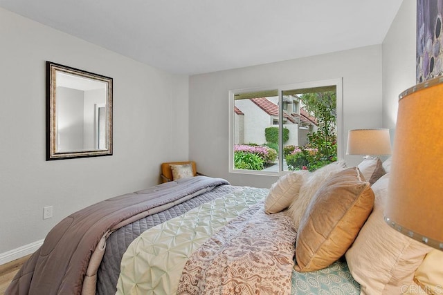 bedroom with baseboards and wood finished floors
