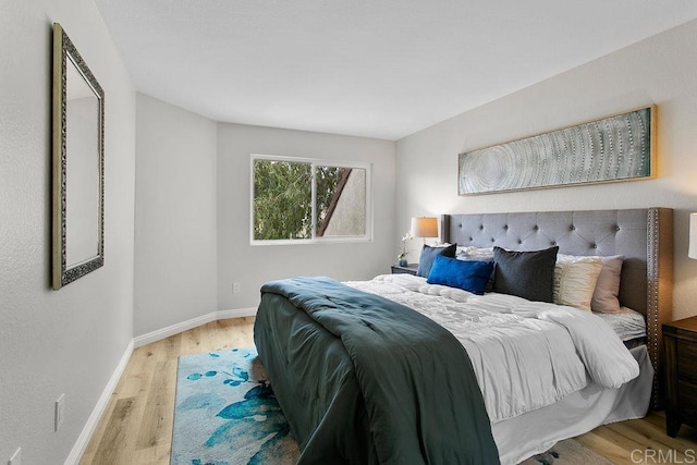 bedroom featuring light wood-style floors and baseboards
