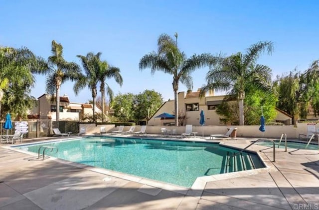 community pool featuring a patio area and fence