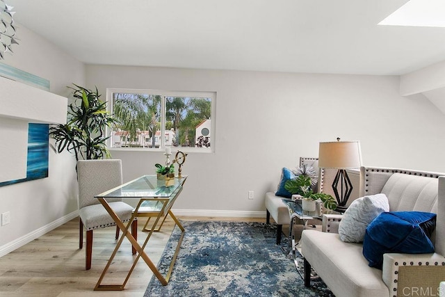 sitting room featuring baseboards and light wood-style flooring