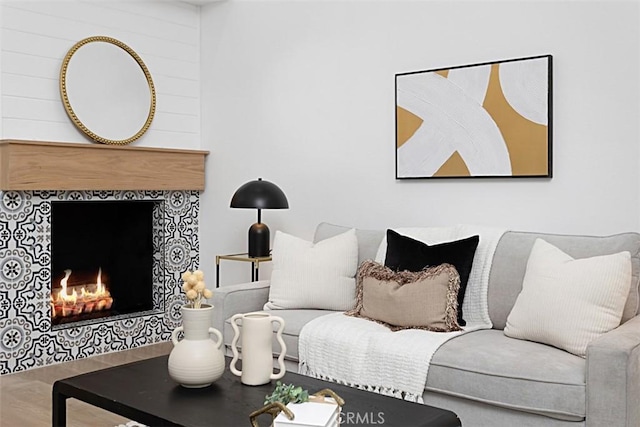 living area featuring a tile fireplace and wood finished floors