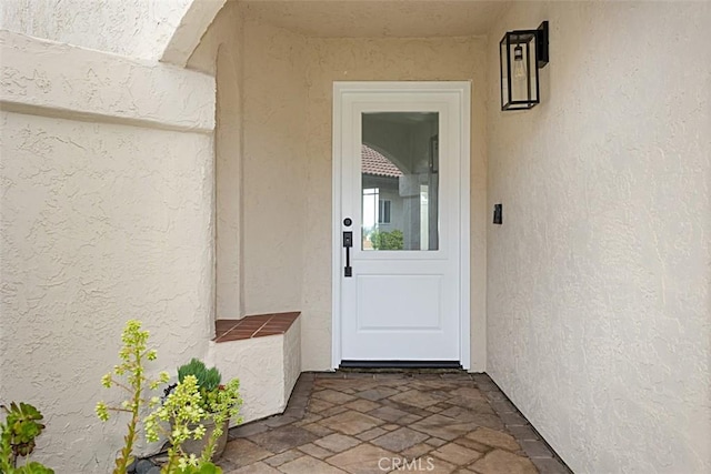 entrance to property featuring stucco siding