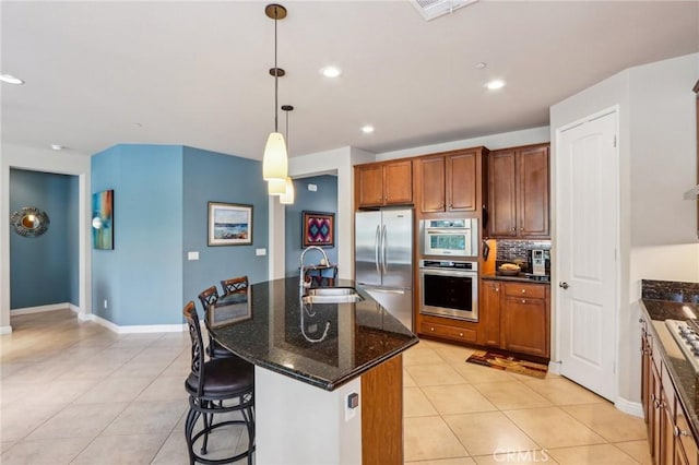 1436 Via Rojas, Hemet, CA 92545 - kitchen with appliances with stainless steel finishes, a sink, light tile patterned flooring, an island with sink, and decorative backsplash