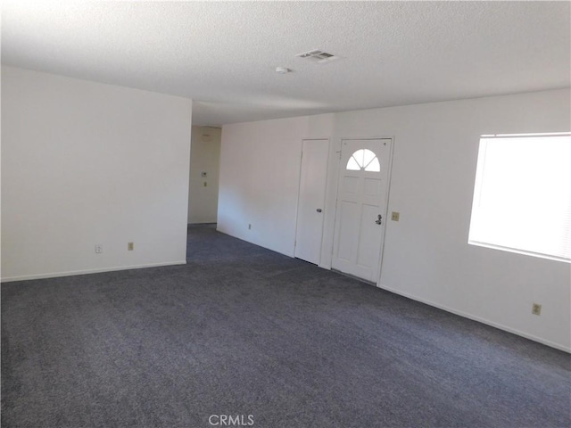 38625 25th St E, Palmdale, CA 93550 - entrance foyer featuring dark colored carpet, a textured ceiling, and baseboards