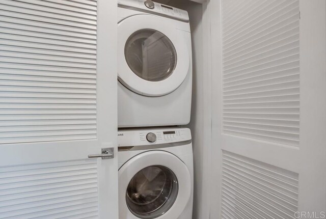 clothes washing area featuring estacked washer and dryer
