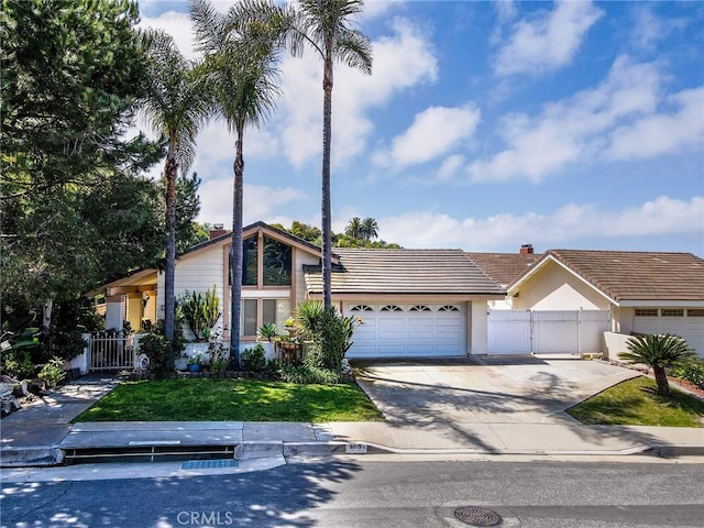 303 Calle Escuela, San Clemente, CA 92672 - mid-century home featuring an attached garage, a tile roof, concrete driveway, stucco siding, and a gate