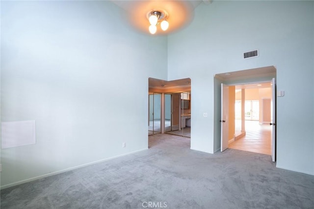 303 Calle Escuela, San Clemente, CA 92672 - empty room featuring carpet, a towering ceiling, and baseboards