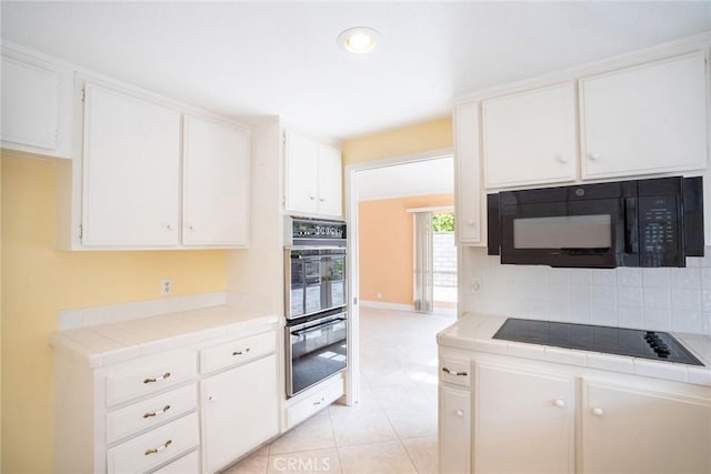 kitchen featuring black appliances, tile countertops, white cabinets, tasteful backsplash, and recessed lighting