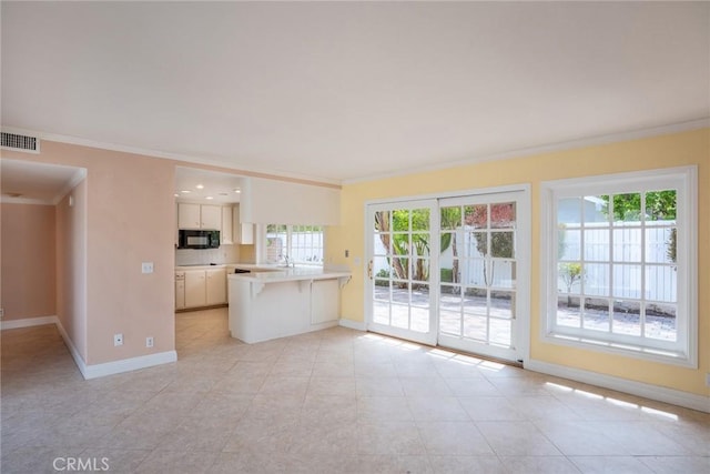 unfurnished living room featuring crown molding, plenty of natural light, baseboards, and light tile patterned floors