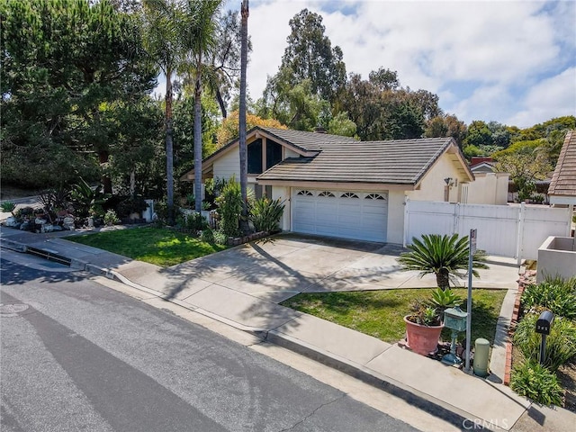 view of front of house featuring a tile roof, driveway, an attached garage, and stucco siding