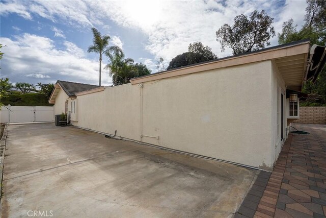 303 Calle Escuela, San Clemente, CA 92672 - view of side of home with stucco siding, a patio, cooling unit, a gate, and fence