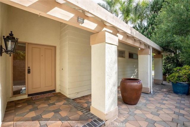 view of exterior entry with a patio