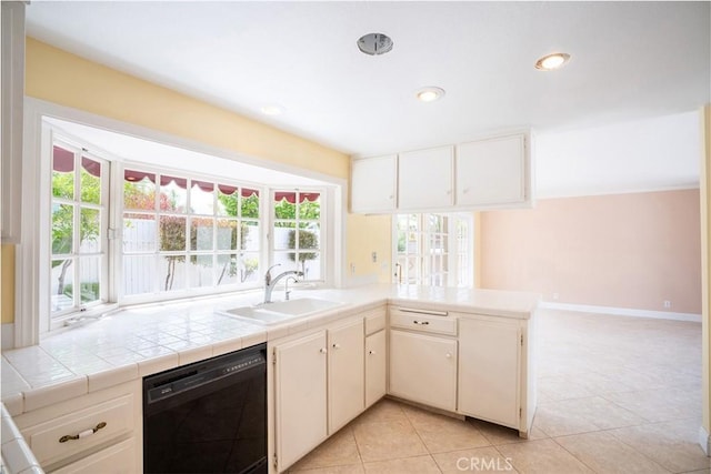 kitchen with black dishwasher, a sink, light tile patterned floors, a peninsula, and recessed lighting