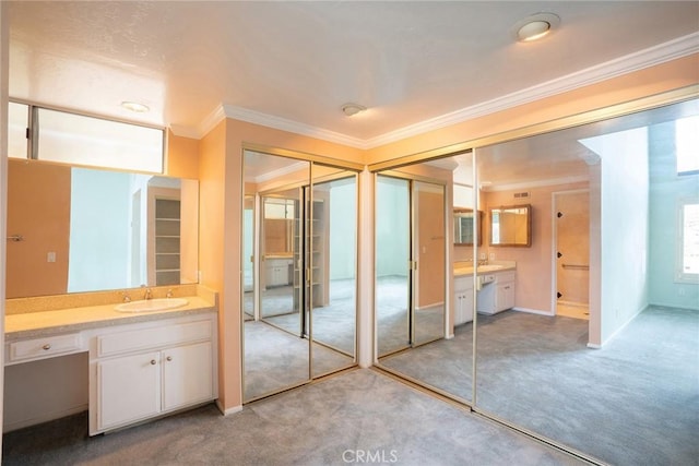 bathroom with crown molding, two vanities, and baseboards
