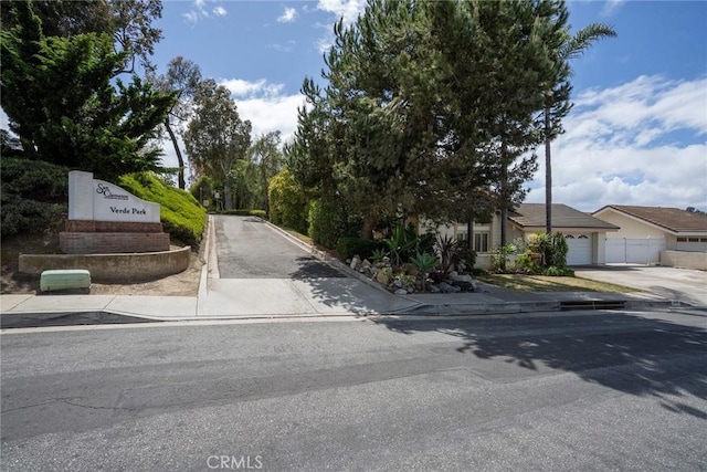 view of asphalt road featuring sidewalks and curbs