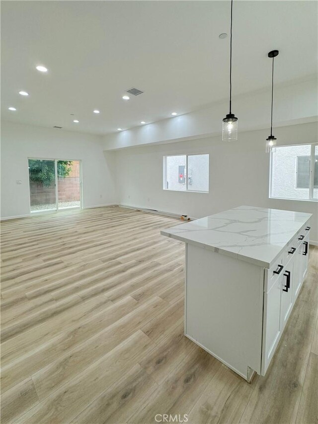 10430 Densmore Ave, Granada Hills, CA 91344 - kitchen with open floor plan, light wood-style floors, a kitchen island, white cabinets, and recessed lighting