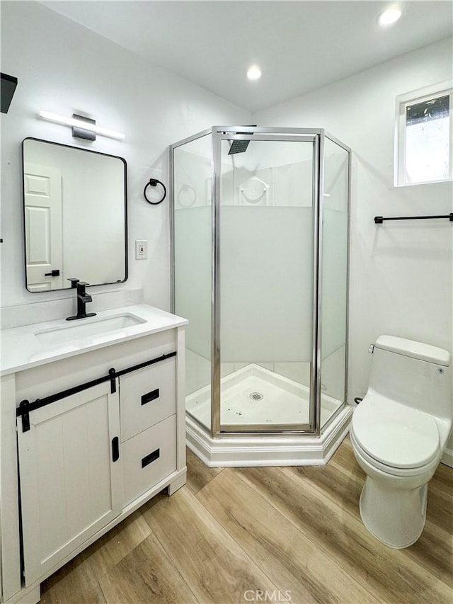10430 Densmore Ave, Granada Hills, CA 91344 - bathroom featuring wood finished floors, a stall shower, vanity, toilet, and recessed lighting