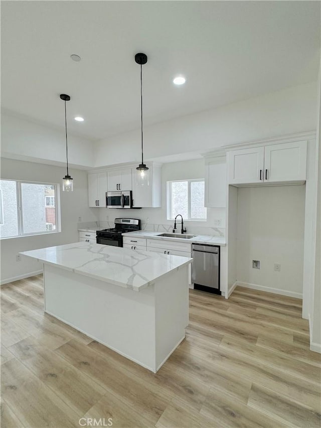 10430 Densmore Ave, Granada Hills, CA 91344 - kitchen featuring stainless steel appliances, light wood finished floors, a center island, white cabinetry, and recessed lighting