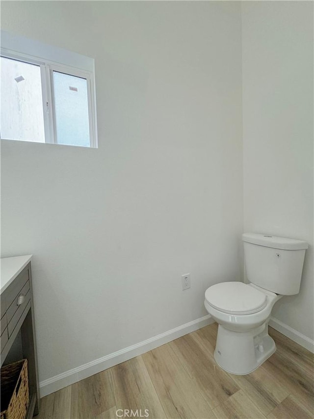 10430 Densmore Ave, Granada Hills, CA 91344 - half bathroom with wood finished floors, baseboards, toilet, and vanity