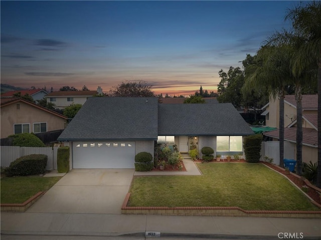 view of front of property featuring a garage, concrete driveway, and roof with shingles
