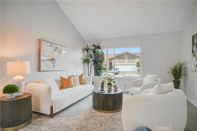 living area with high vaulted ceiling and baseboards