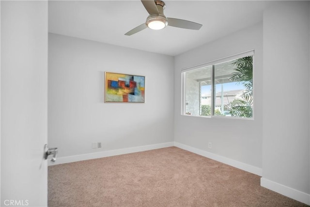 spare room featuring carpet flooring, baseboards, and a ceiling fan