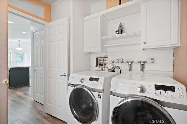 laundry area with cabinet space, washing machine and dryer, and wood finished floors