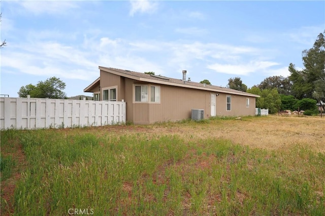 view of side of home featuring fence and central air condition unit