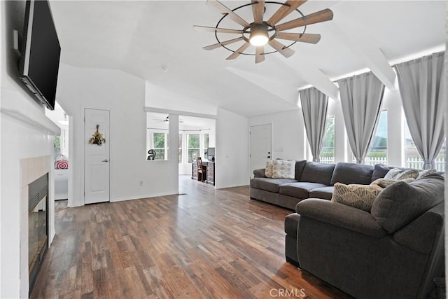 living area featuring ceiling fan, a glass covered fireplace, wood finished floors, and lofted ceiling