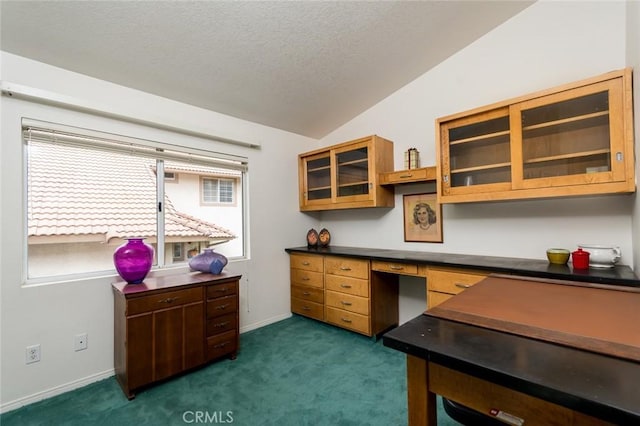 21714 Agajanian Ln, Saugus, CA 91350 - home office with dark carpet, a textured ceiling, vaulted ceiling, built in desk, and baseboards