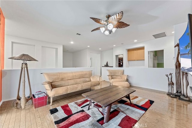 living room featuring a ceiling fan, hardwood / wood-style flooring, and recessed lighting