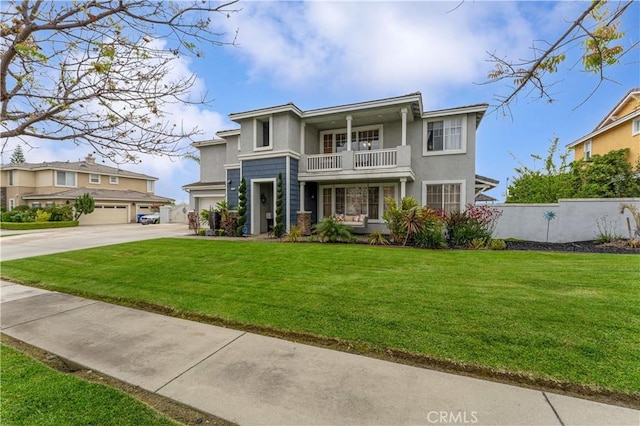 view of front facade featuring a balcony, concrete driveway, an attached garage, and stucco siding