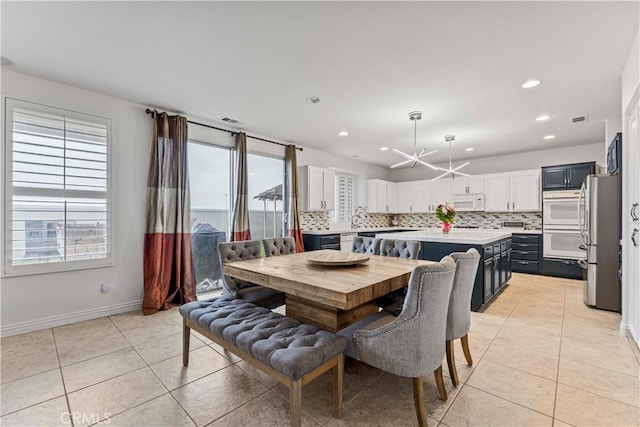 dining area featuring light tile patterned floors, a chandelier, recessed lighting, and baseboards