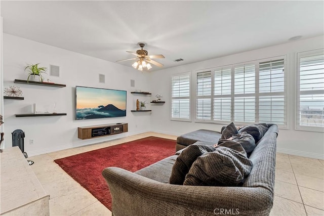 tiled living area featuring ceiling fan and baseboards