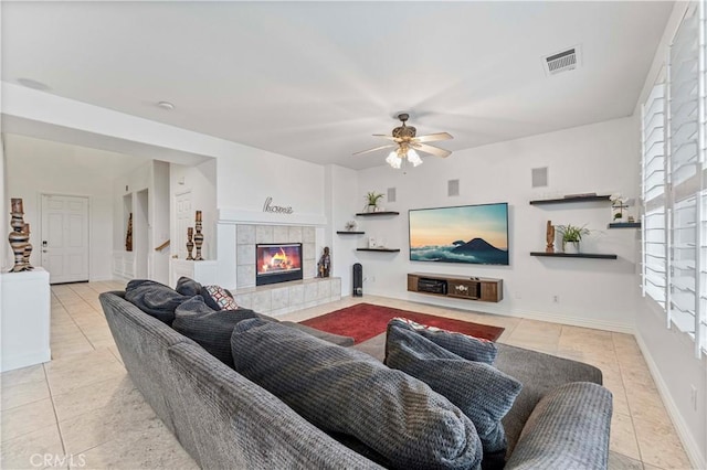 living area featuring tile patterned floors, plenty of natural light, a tile fireplace, and ceiling fan