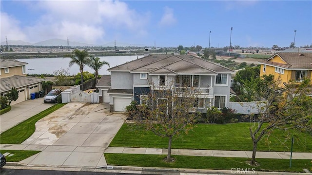 view of front facade with concrete driveway, stucco siding, a water view, a tile roof, and a garage