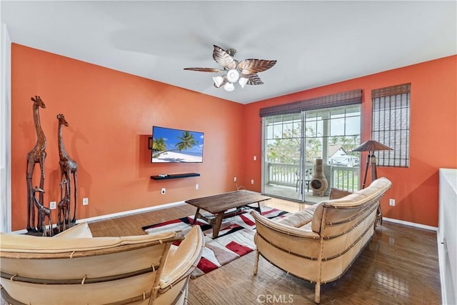 living area with hardwood / wood-style floors, baseboards, and ceiling fan