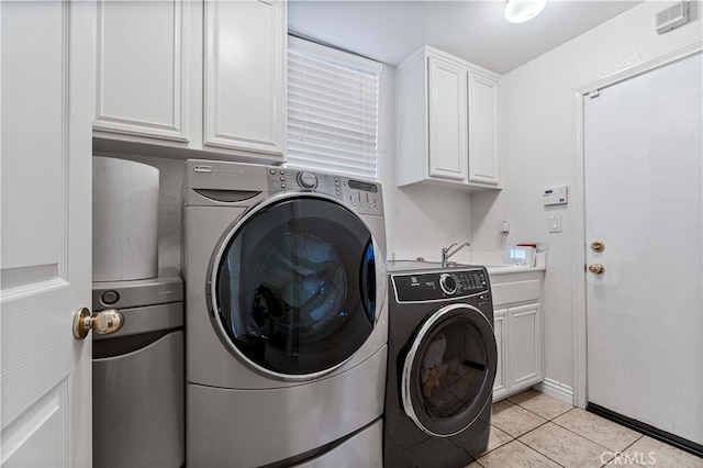 washroom with cabinet space, separate washer and dryer, and light tile patterned flooring
